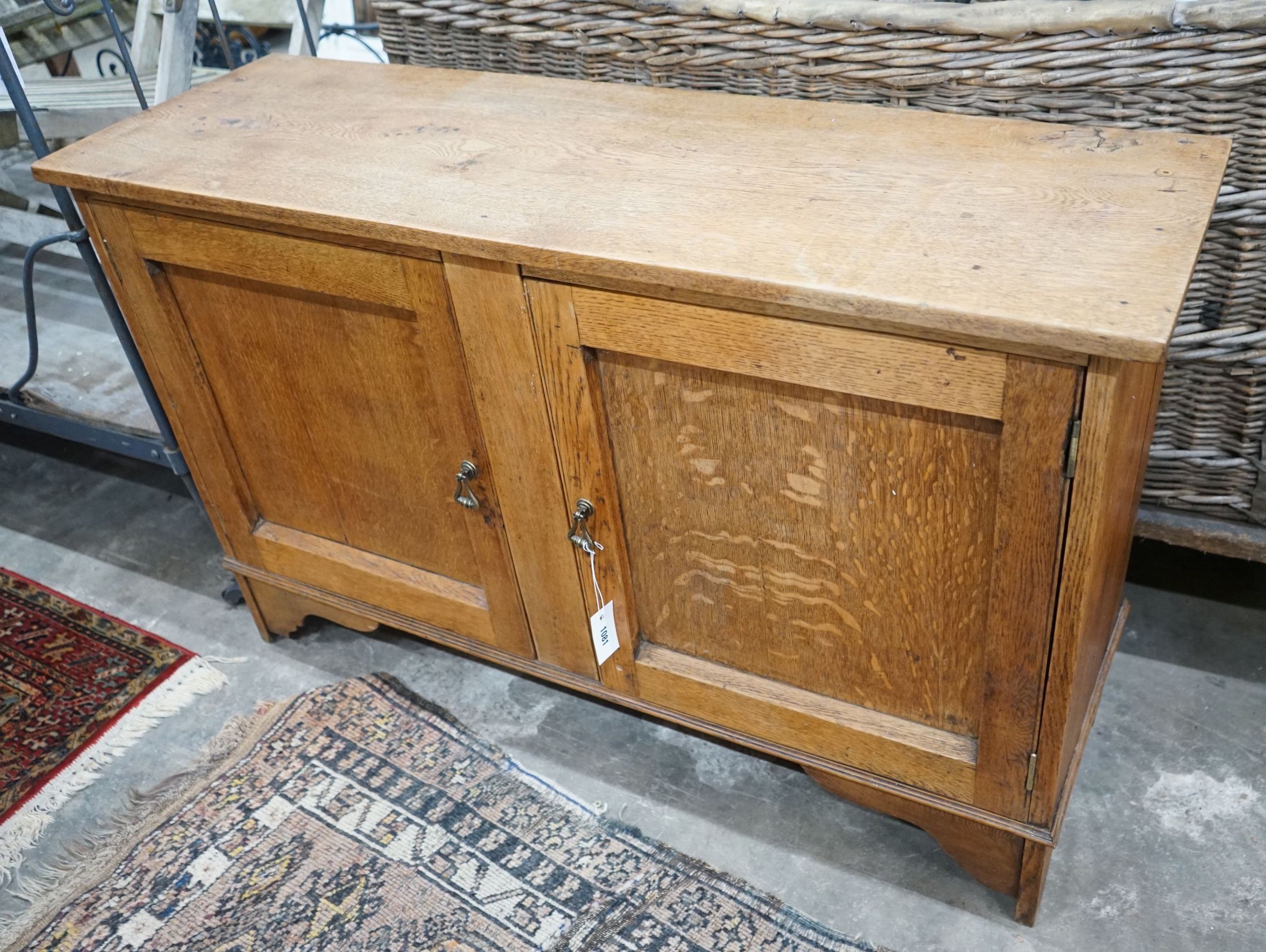 A 1920's two door oak low cabinet, width 120cm, depth 39cm, height 76cm